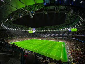 A captivating night football match at a packed stadium in England, showcasing dynamic gameplay and vibrant atmosphere.